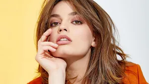 Alluring Emma Mackey Dressed In Fiery Orange Wallpaper