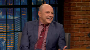 American Actor And Comedian Rob Corddry Posing Against A Colorfully Painted Wall. Wallpaper