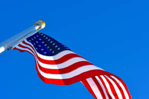 American Flag Waving Against Blue Sky Wallpaper