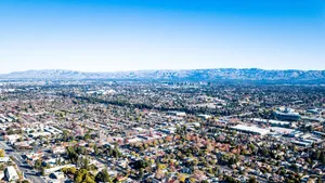 An Aerial View Of A City With Mountains In The Background Wallpaper