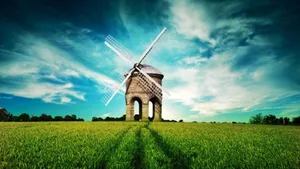 An Aerial View Of A Windmill Against A Grass-filled Landscape Wallpaper