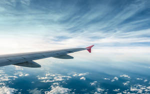 An Aerial View Of An Airplane Soaring Through The Sky Wallpaper