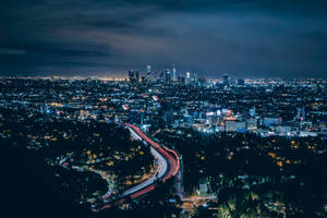 An Aerial View Of The Nighttime Los Angeles Skyline Wallpaper