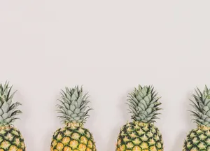 An Array Of Pineapples Of Different Sizes, Shapes, And Colors All Lined Up Side By Side. Wallpaper