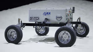 An Astronaut Drives The Lunar Rover Across The Moon's Surface Wallpaper