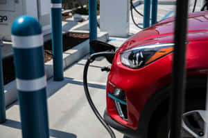 An Electric Vehicle Charging At A Charging Station Wallpaper
