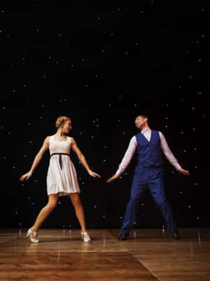 An Energized Couple Demonstrating Lively Swing Dance Moves. Wallpaper