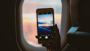 An Iphone In The Plane Window Wallpaper