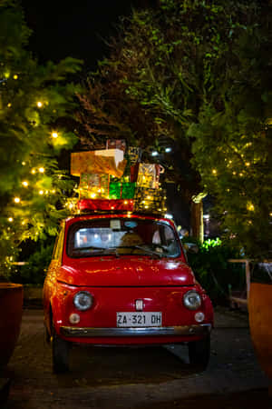 An Old-fashioned Red Pickup Truck Festively Decorated For Christmas Wallpaper