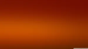 An Orange And Brown Background With A Light Wallpaper