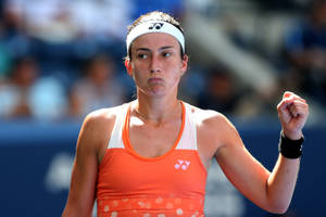 Anastasija Sevastova In Action - Wielding Her Orange Yonex Top On Court Wallpaper