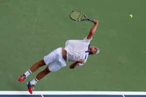 Andy Roddick Delivering A Power-packed Tennis Smash Mid-air. Wallpaper