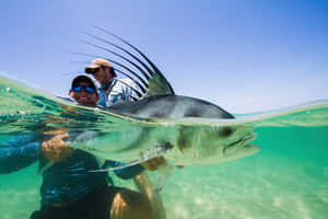Anglerwith Roosterfish Catch Wallpaper