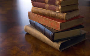 Antique_ Books_ Stacked_on_ Table Wallpaper