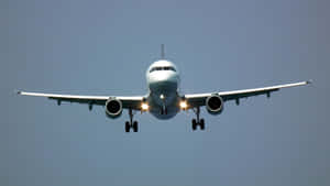 Approaching Aircraft Under Blue Sky Wallpaper