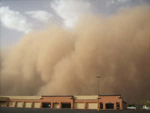 Approaching_ Dust_ Storm_ Over_ Building Wallpaper