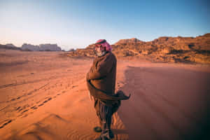 Arab Man Standing In Desert Wallpaper