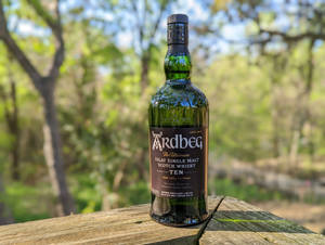 Ardbeg Ten Whisky Bottle In Woods Wallpaper