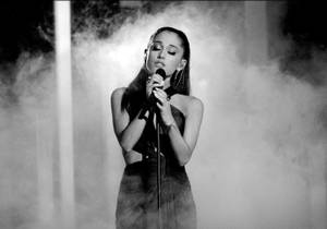 Ariana Grande Commanding The Stage With Her Signature Smoky Style Wallpaper