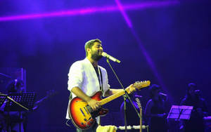 Arijit Singh Delivering A Powerful Performance With His Band Wallpaper