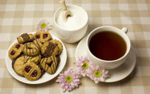 Aromatic Floral Tea In A Glass Teapot With Fresh Flowers Surrounding Wallpaper