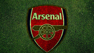 Arsenal Logo On Grass Field Wallpaper