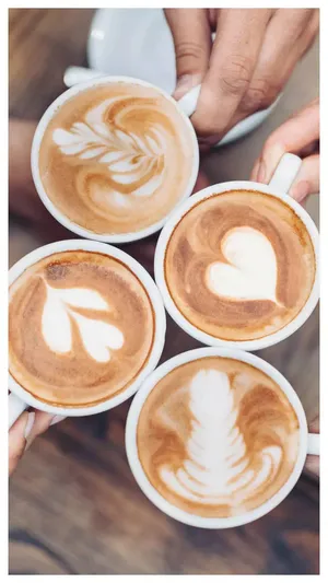 Artistic Latte Coffee Cups Shared Among Friends Wallpaper