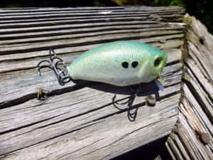 Assortment Of Colorful Fishing Bait On A Wooden Table Wallpaper