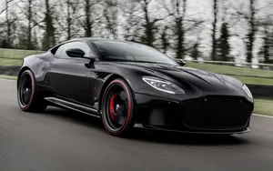 Aston Martin Dbs Superleggera Cruising On An Open Road Wallpaper
