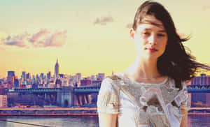 Astrid Berges-frisbey Posing Elegantly Against A Blue Background Wallpaper