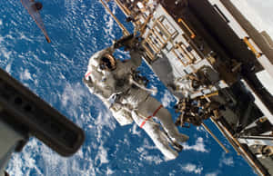 Astronauts Working On A Space Station Orbiting Earth Wallpaper