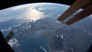 Astronauts Working On The International Space Station (iss) Above Earth Wallpaper