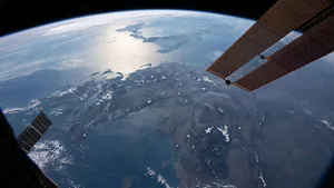 Astronauts Working On The International Space Station (iss) Above Earth Wallpaper