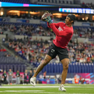 Athlete Catching Football During Practice Wallpaper