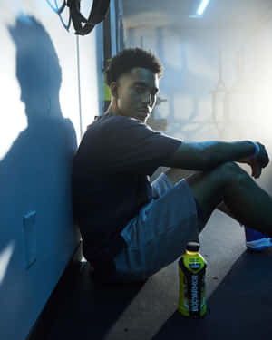 Athlete Restingin Blue Gym Setting Wallpaper