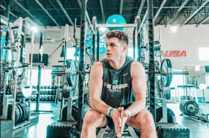 Athlete Restingin Gym Workout Break Wallpaper