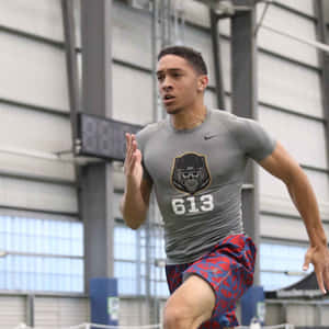 Athlete Running Indoor Training Session Wallpaper