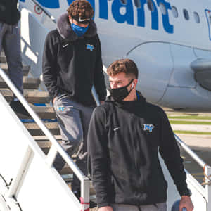 Athletes Disembarking Airplane Wallpaper