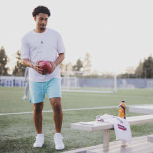 Athletewith Footballon Field Wallpaper