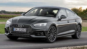 Audi A5 Sportback Driving Through A Scenic Road Wallpaper