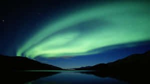 Aurora Borealis Over Lakeat Night Wallpaper