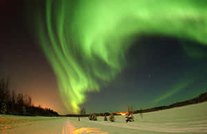 Aurora Borealis Over Snowy Landscape.jpg Wallpaper