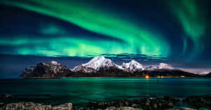 Aurora Borealis Over Snowy Mountains Wallpaper