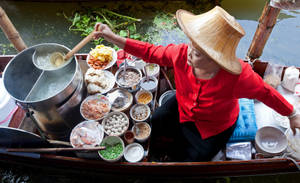 Authentic Flavors Of Bangkok - A Food Stall At A Floating Market Wallpaper