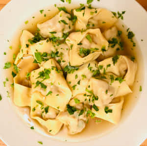 Authentic Tortellini In Brodo Garnished With Fresh Greens Wallpaper