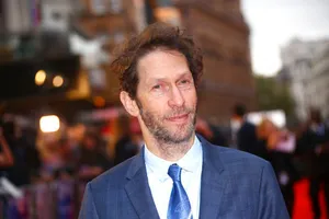 Award-winning Actor Tim Blake Nelson Smiling In A Studio Photoshoot Wallpaper