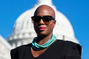 Ayanna Pressley Standing In Front Of The Capitol Dome Wallpaper