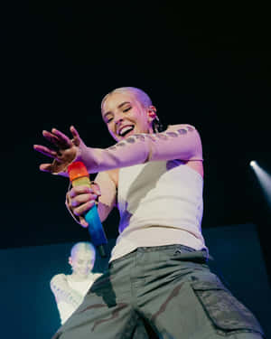 Bald Performer Singingon Stage.jpg Wallpaper
