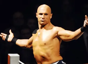 Bald Wrestler Gesturingin Ring Wallpaper