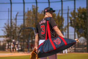 Baseball Player Dylan Crews Walking With Equipment Wallpaper